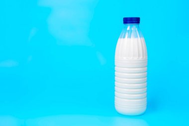 Mavi zemin üzerinde doğal taze süt şişesi ve kopyalama alanı