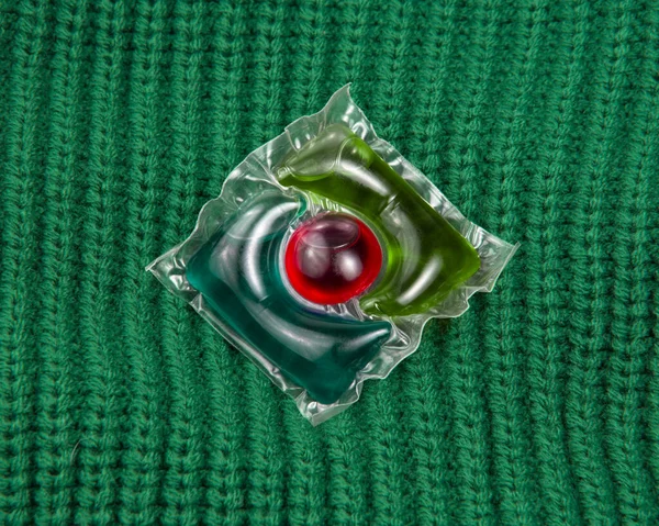 Washing Gel Capsule Liquid Powder Green Knitted Fabric Background — Stock Photo, Image