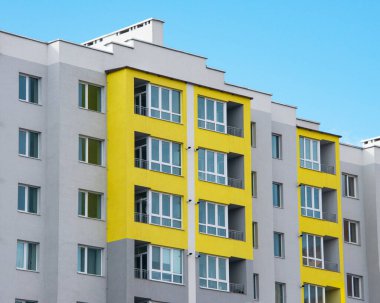 Gri sarı pantonlu yeni bina birçok kat ve mavi gökyüzü arka planı