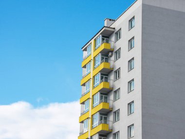Gri sarı pantonlu yeni bina birçok kat ve mavi gökyüzü arka planı