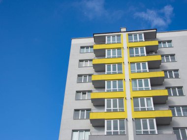 Gri sarı pantonlu yeni bina birçok kat ve mavi gökyüzü arka planı