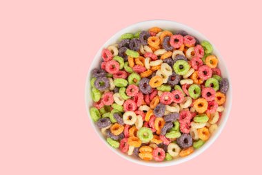Delicious and nutritious fruit cereal loops multicolored flavorful on white background, healthy and funny addition to kids breakfast