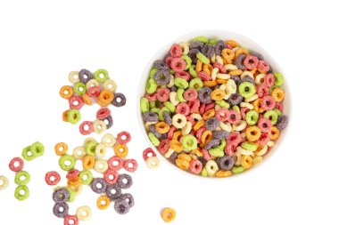 Delicious and nutritious fruit cereal loops multicolored flavorful on white background, healthy and funny addition to kids breakfast