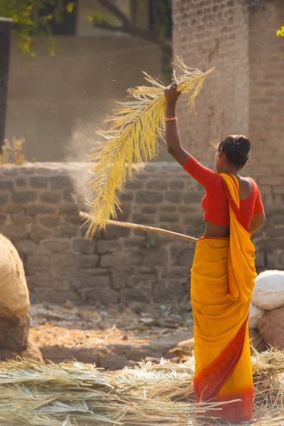 Indisk kvinna slår palm leaf halm tak — Stockfoto