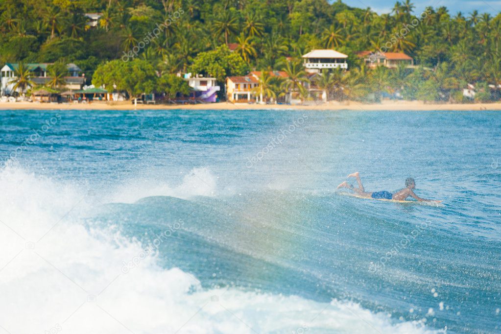 Sri Lankan Surfer Paddling Over Wave Unawatuna