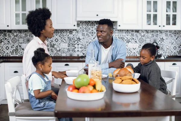 African American young parents with two little daughters having breakfast on kitchen — Stock Photo, Image