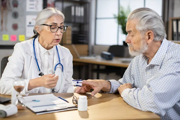 Dokter perempuan memantau saturasi pasien pria lanjut usia — Stok Foto