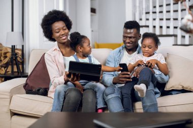 Neşeli Afrikalı aile tablette oyun oynuyor.