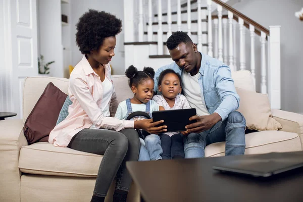 Família africana sentada no sofá e usando tablet — Fotografia de Stock