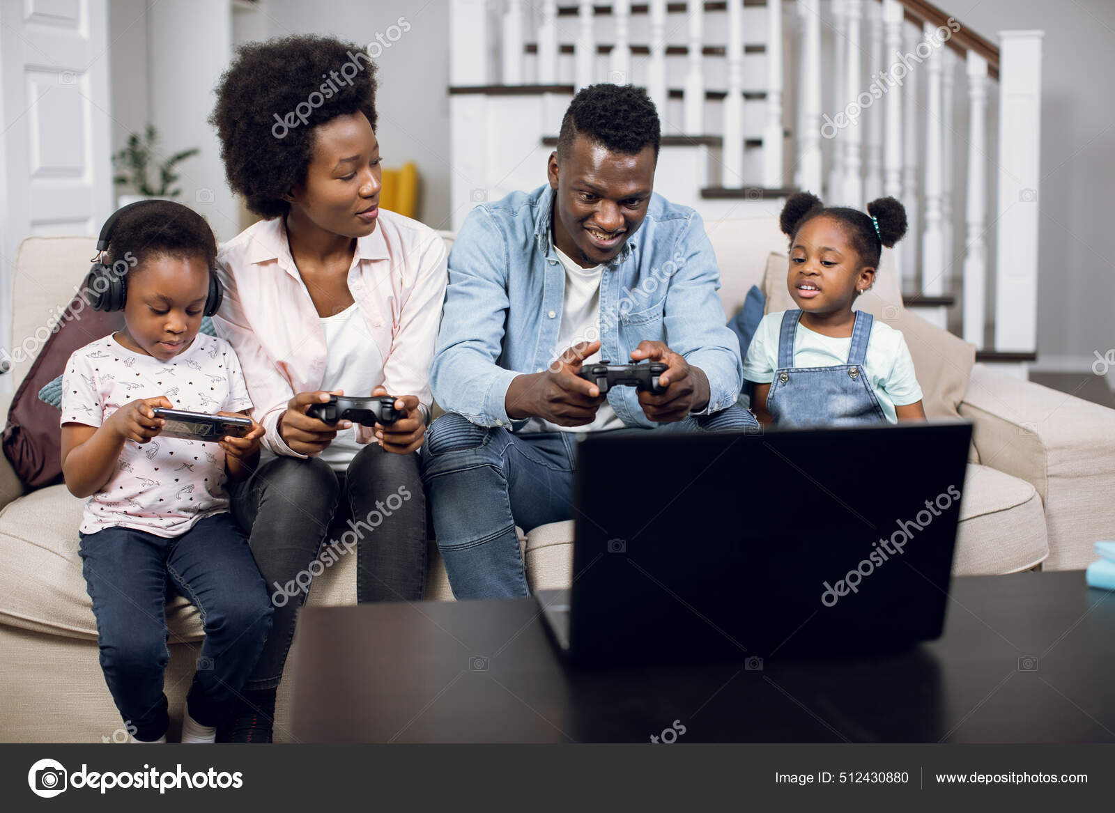Two kids and parents using modern gadgets during free time — Stock
