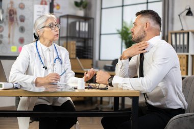 Takım elbiseli adam doktor dolabında boğaz ağrısı şikayeti var.