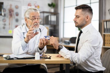 Doktor nabız oksimetresi olan hastanın doygunluğunu test ediyor.