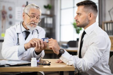 Doktor nabız oksimetresi olan hastanın doygunluğunu test ediyor.