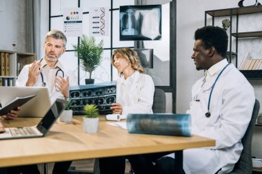Çok kültürlü doktorlar hasta tedavisi hakkında toplantı yapıyorlar.