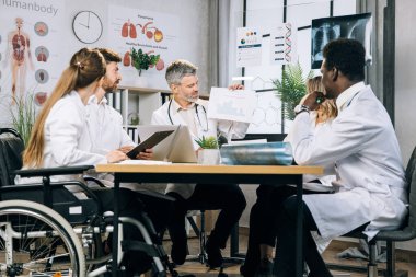 Bir grup tıp uzmanı ofiste tartışıyorlar.