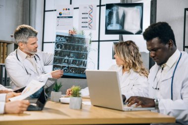 Ofiste röntgen taraması yapan bir grup çok ırklı doktor.