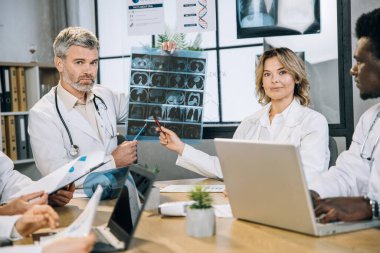 Ofiste röntgen taraması yapan bir grup çok ırklı doktor.