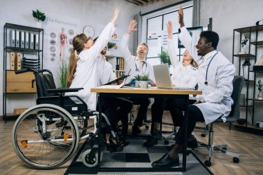 Muhtelif doktor grupları toplantının ardından el kol hareketi yaparak gülümsüyor.