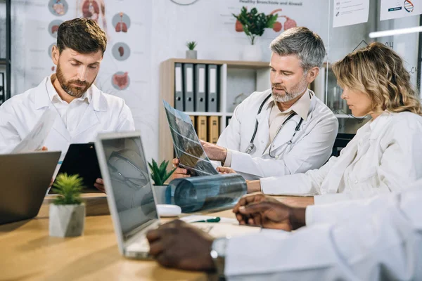 Travailleurs médicaux multiraciaux examinant les résultats des radiographies — Photo