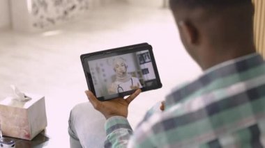 Arap Müslüman kadın doktor hasta erkek hastaların semptomlarını video konferansında açıklıyor.