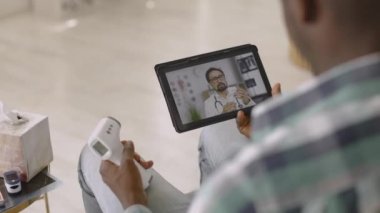 Afrikalı adamın bulanık görüntüsü, doktorun video bloğu, termometrenin nasıl kullanılacağını açıklayan