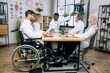 Çok ırklı doktorlar röntgen taramasının sonuçlarını tartışıyor