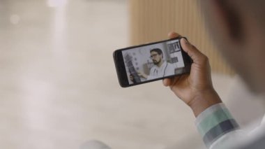 Evdeki adam, erkek doktorla görüntülü görüşme yapıyor.