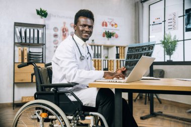 Laptop kullanan ve röntgen taraması yapan pozitif Afrikalı doktor.