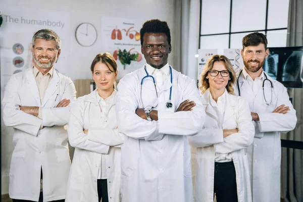 Multiraciala läkare i uniform stående på kontoret rum — Stockfoto