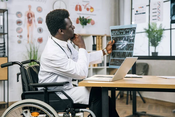 African doctor who using wheelchair examining x ray scan