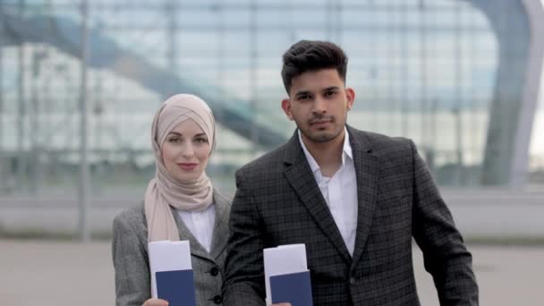 Muslimisches Paar posiert vor dem Flughafen vor der Kamera und zeigt seine Pässe und Tickets — Stockvideo