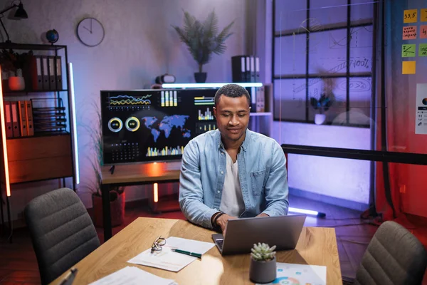 Afro-Américain assis au bureau et travaillant sur ordinateur portable — Photo