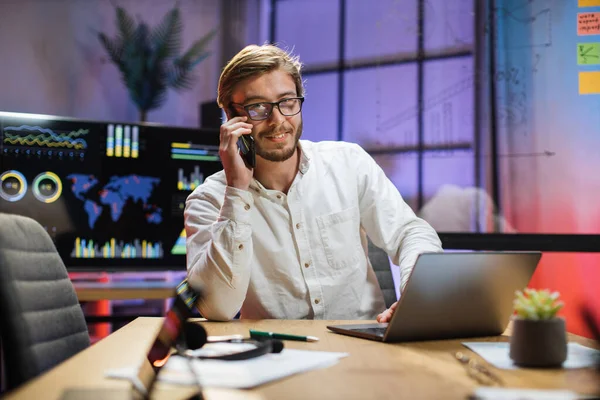 Manajer kantor memiliki percakapan seluler saat bekerja pada laptop — Stok Foto