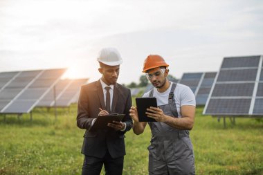 İş adamı teknisyenle güneş panelleri hakkında konuşuyor