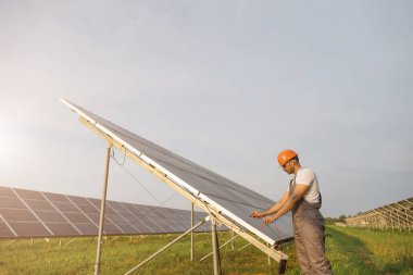 Güneş pillerindeki voltajı dışarıda ölçen teknisyen.