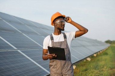 Güneş istasyonunda panosu olan bir teknisyen.