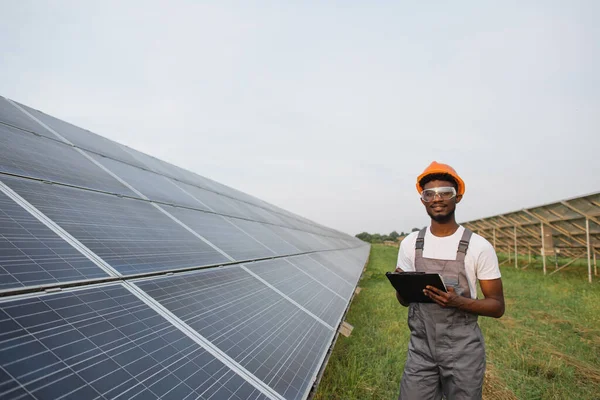 Sanayi işçisi güneş istasyonunda panoya yazı yazıyor.