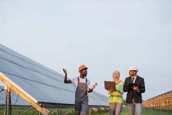 Afroamerykanin męski tecnhician pokazuje słoneczną stację dla dwóch inspektorów — Zdjęcie stockowe