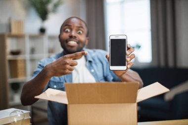 Erkek blogcu yeni akıllı telefonla paket açıyor