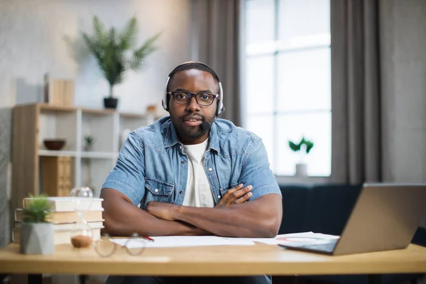 Africain en casque et lunettes assis au bureau — Photo