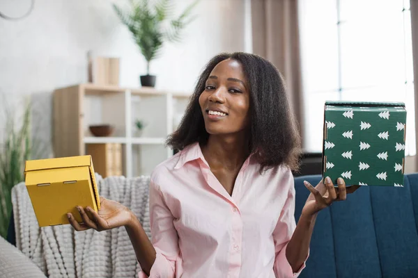 Afro-Amerikaanse vrouw zit op de bank met geschenkdozen — Stockfoto