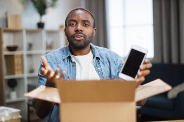 Erkek blogcu yeni akıllı telefonla paket açıyor