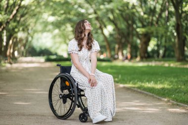 Engelli mutlu kadın yaz parkında vakit geçiriyor.