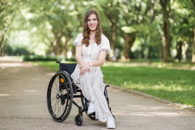 Fiziksel engelli bir kadın parkta vakit geçiriyor.