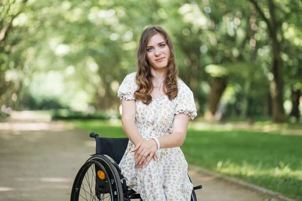 Fiziksel engelli bir kadın parkta vakit geçiriyor.