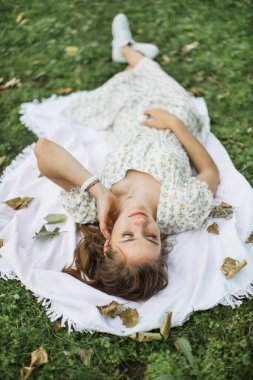 Yeşil park arasında gülümseyen fiziksel engelli bir kadın.