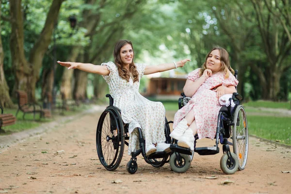 Ευτυχισμένες κυρίες σε αναπηρικά καροτσάκια ποζάρουν στην κάμερα του πάρκου — Φωτογραφία Αρχείου
