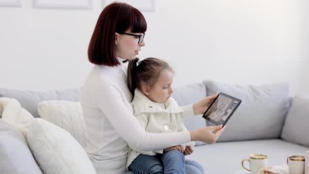 Mother and little daughter with running nose having video call at home with her female confident Arabic doctor — 图库视频影像