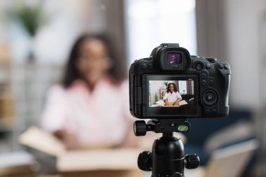 Afrikalı Amerikalı bir kadın paketleri açıyor ve video kaydediyor.