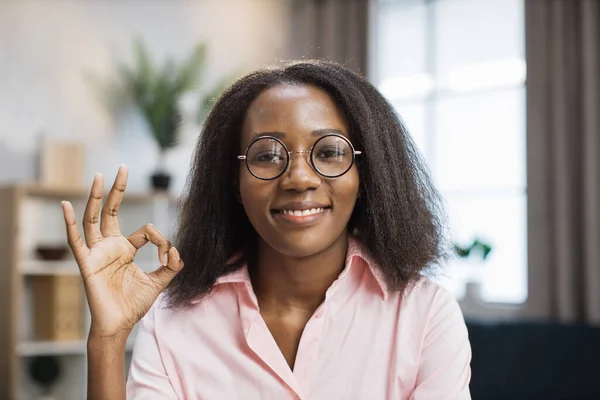 Vrouwelijke tutor in bril zittend aan bureau met boeken — Stockfoto